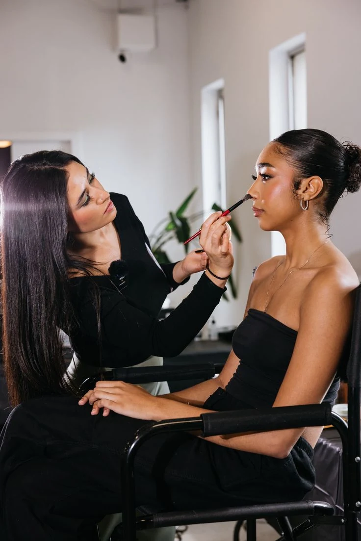A makeup artist applying makeup to a client